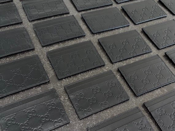 Black GG embossed cardholders laid out in rows