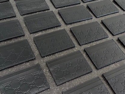 Black GG embossed cardholders laid out in rows