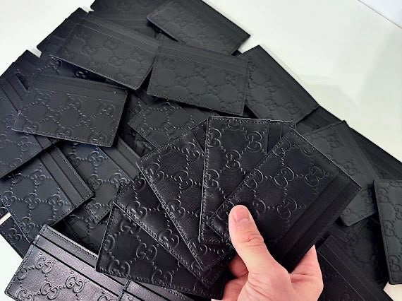 Stack of black GG embossed cardholders, lightly used